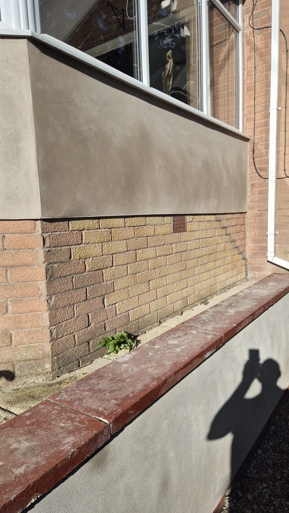 Freshly completed sand and cement render finish meeting the original brickwork on a Chesterfield property